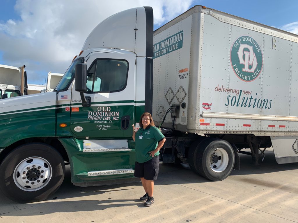 Billie Vasquez stands smiling in front of her Old Dominion truck